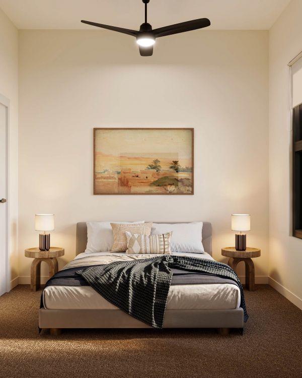 Minimalist bedroom with a bed, nightstands, lamps, wall art, and a ceiling fan, lit by natural light.