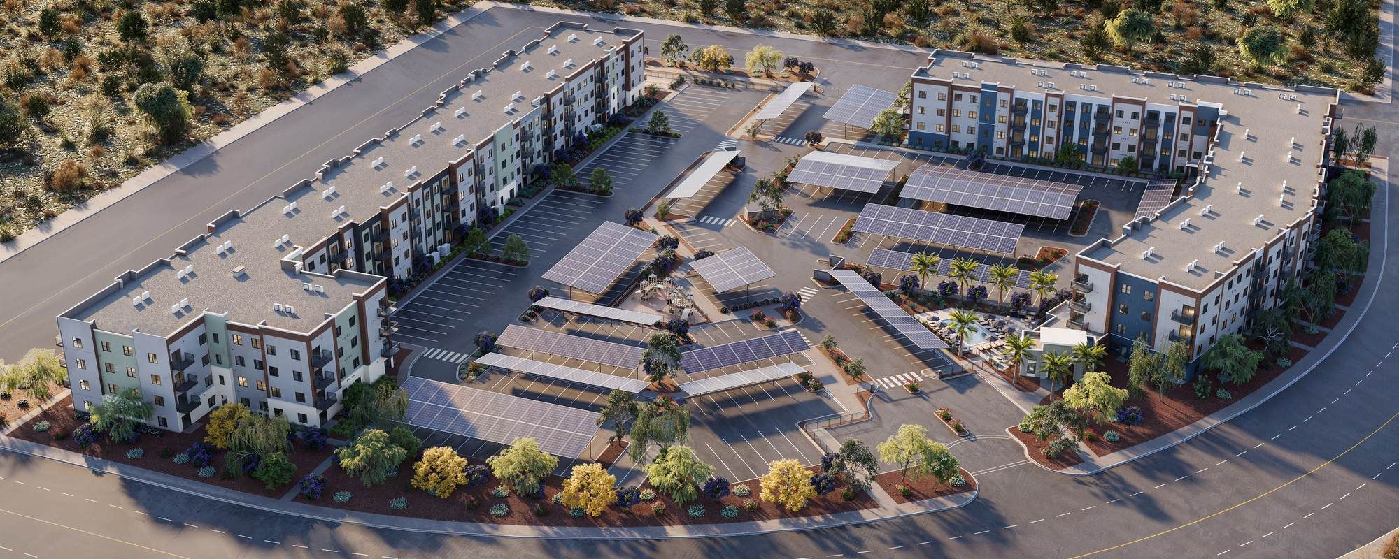 Aerial view of a modern apartment complex with solar panels and surrounding desert landscaping.